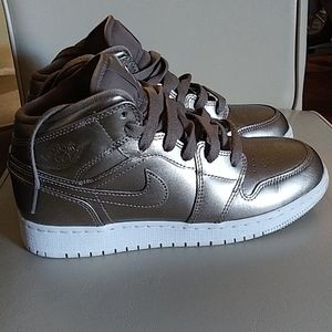 Jordan 1 Mid metallic light gold color.